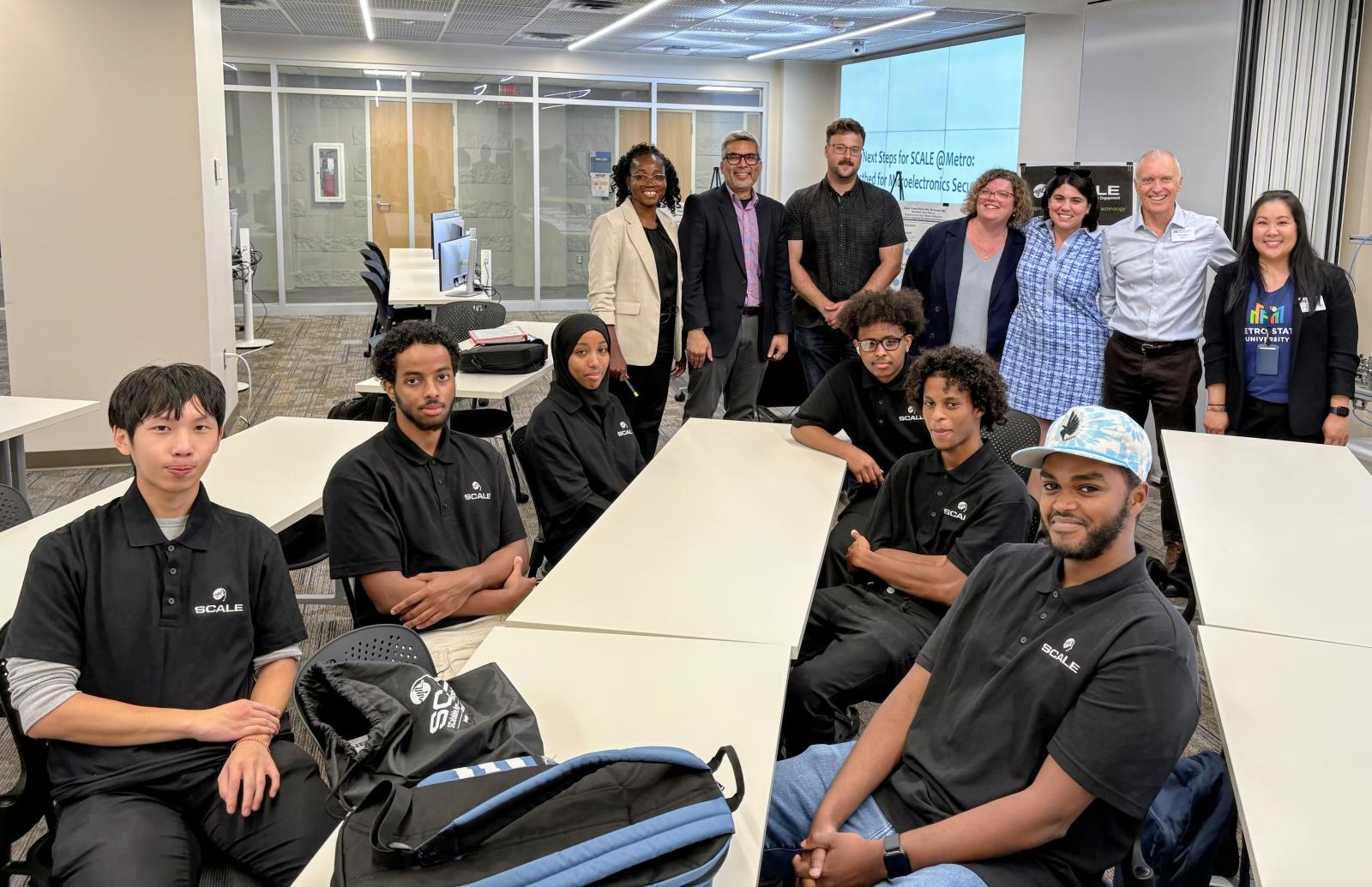 a group of people posing for a photo in a computer lab