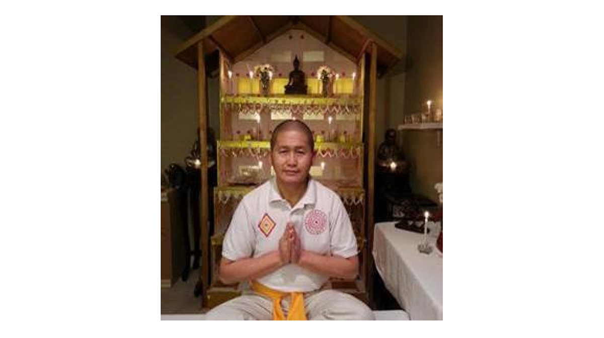 A person in a praying position in front of a shrine