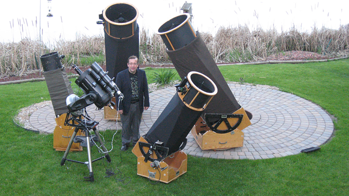 a person stands outside among several large telescopes