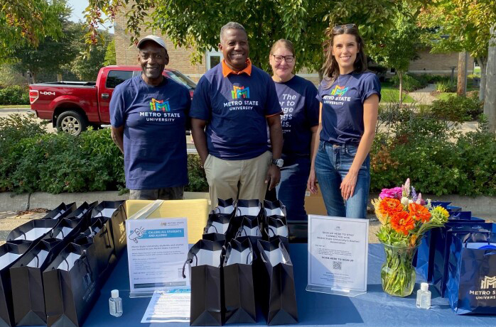 A group of volunteers poses behind a table at an event