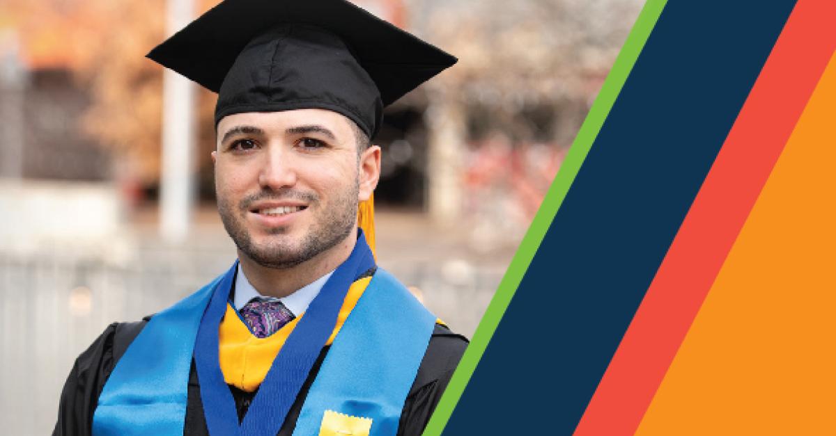 A person in cap and gown poses for a portrait next to diagonal striped lines