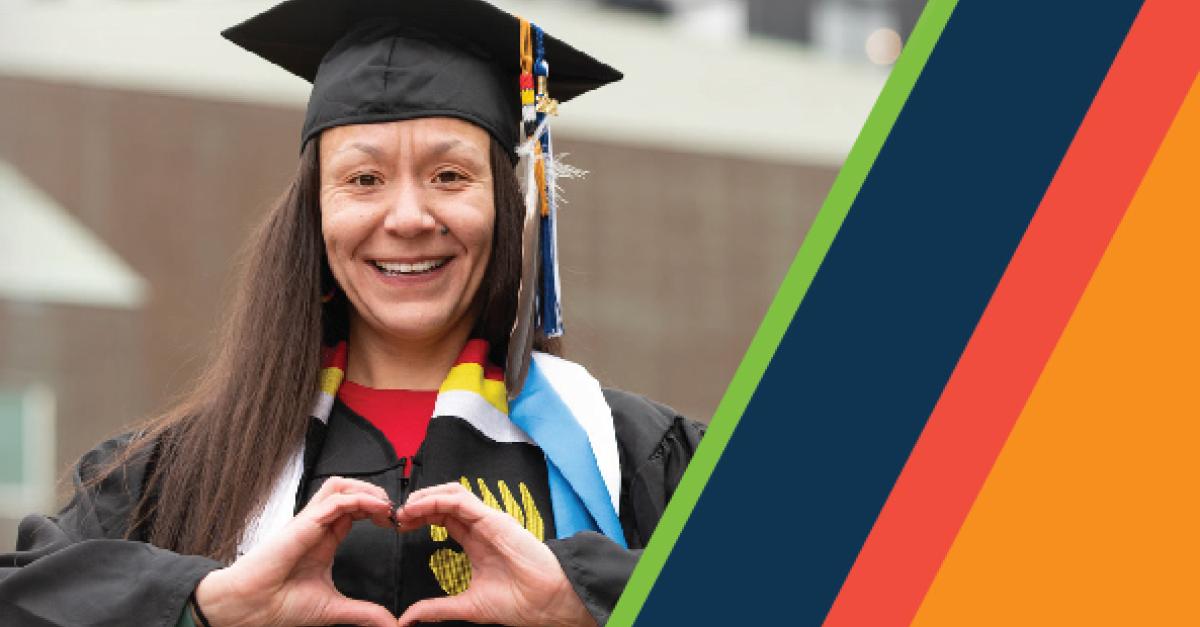 A person in cap and gown poses for a picture next to diagonal striped lines