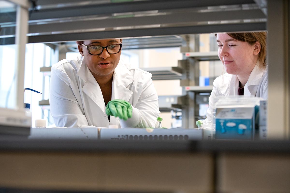 An instructor works one on one with a student in a lab