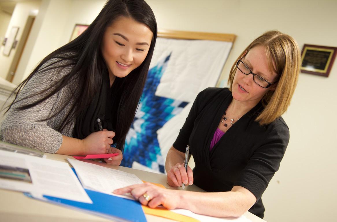 A student reviews documents with a Metro State staff member