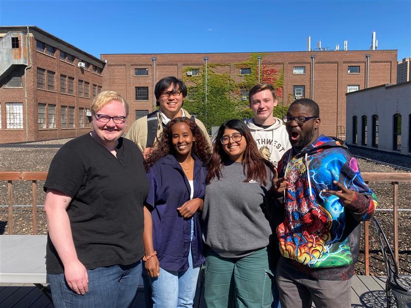 A group of students pose for a picture outside