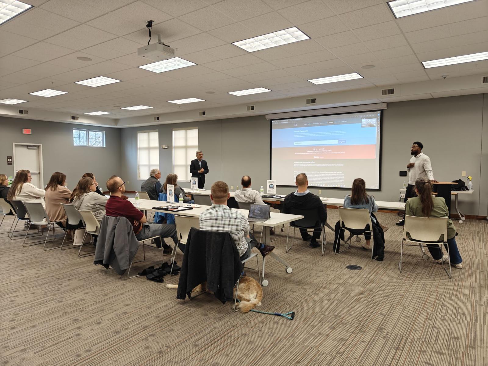 A group of people in a classroom attending a training on cyber security