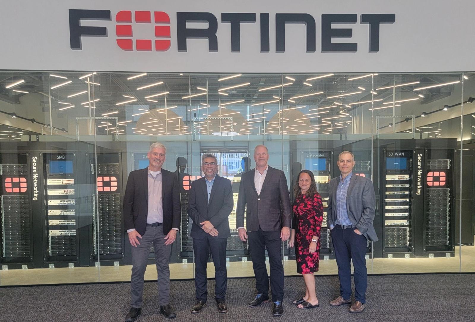 A group of people pose for a picture outside Fortinet's headquarters