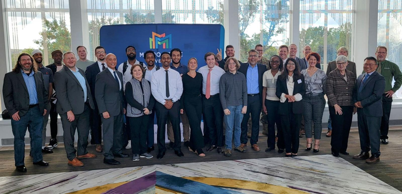 A group of people pose for a picture in the New Main Great Hall