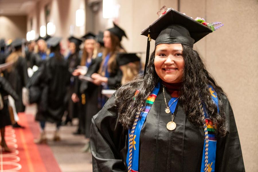 A woman in cap and gown posing in front of others