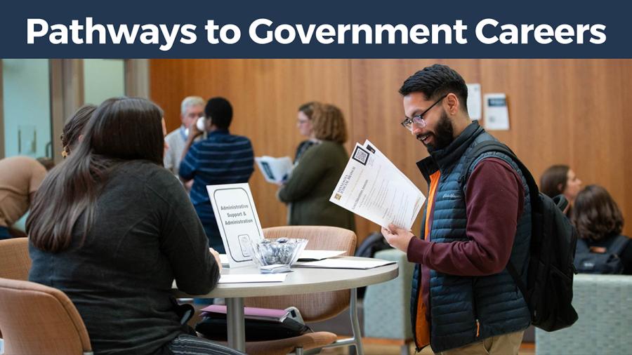 Pathways to government careers with a person looking over papers at a table with other people behind them